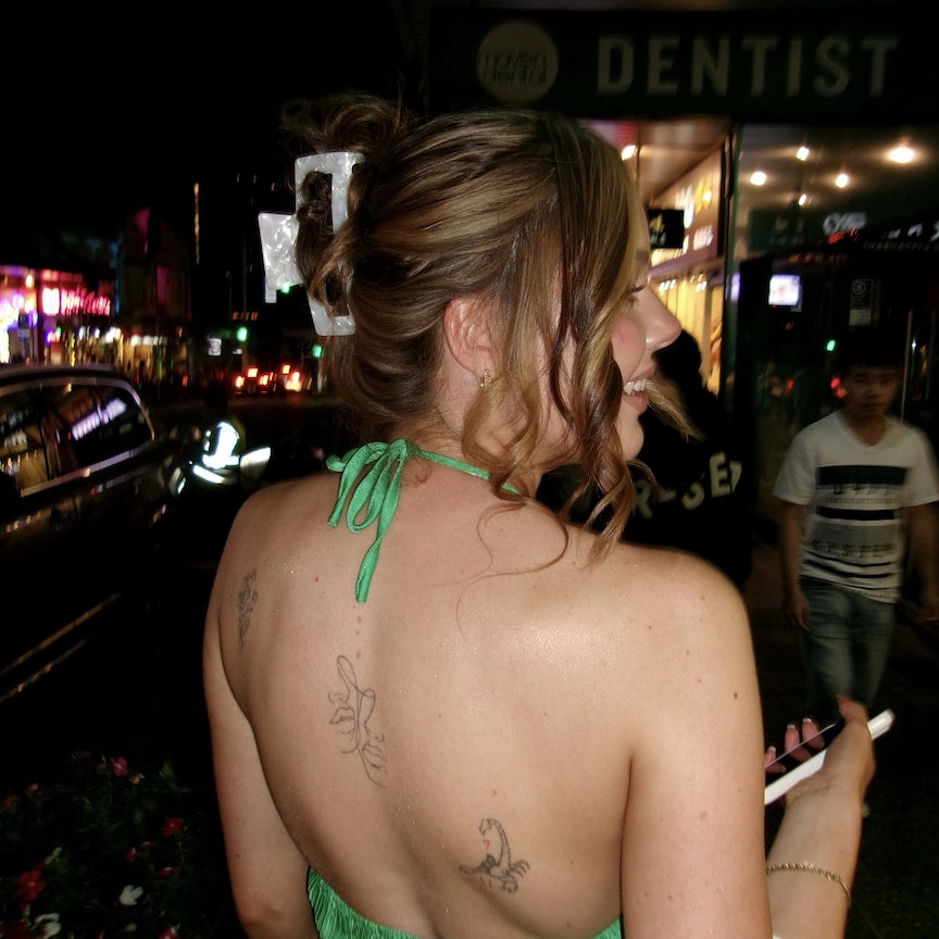 woman with oyster claw clip and green backless top going out during the night