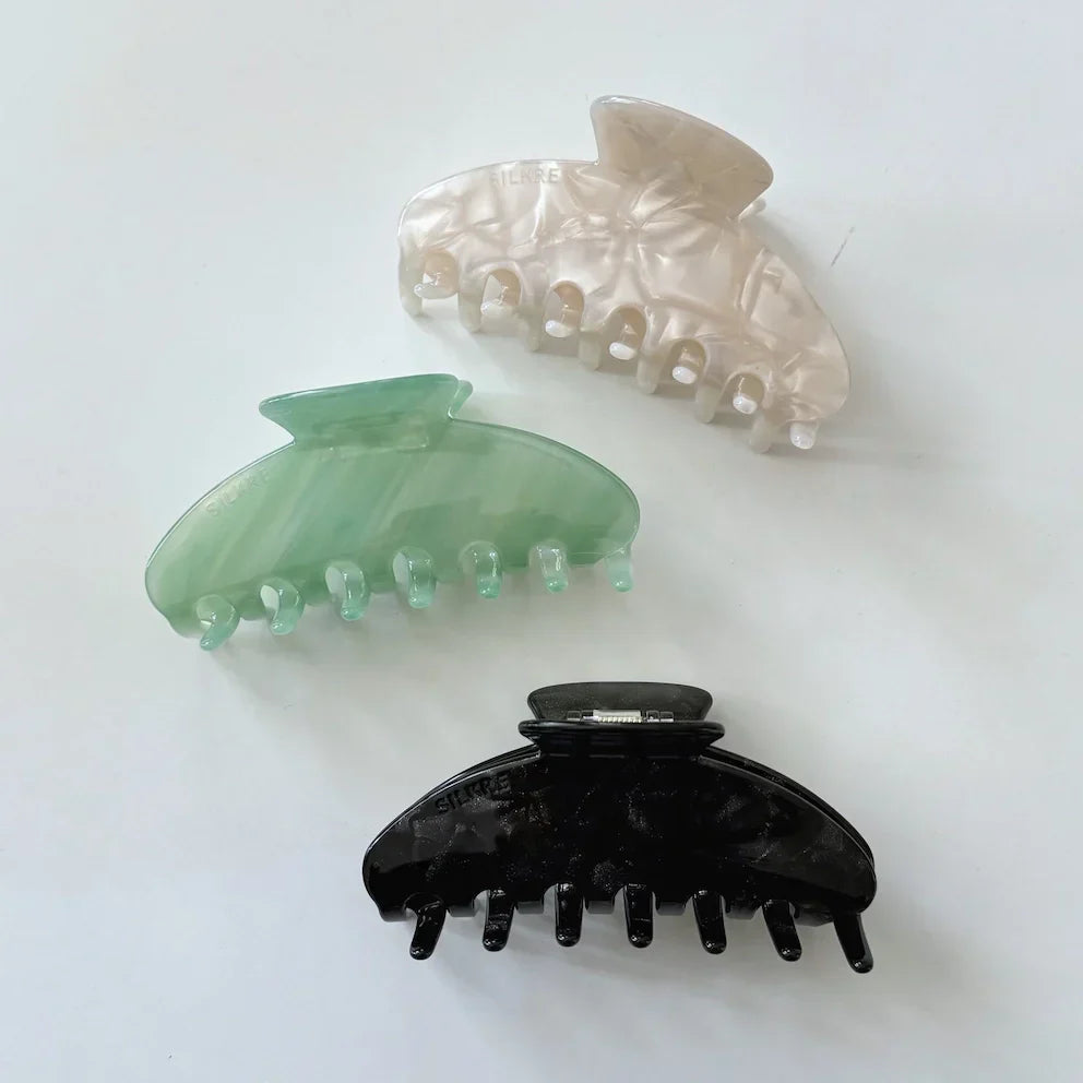 large claw clip designed for thin hair in a jade green, marble white and black marble colour 