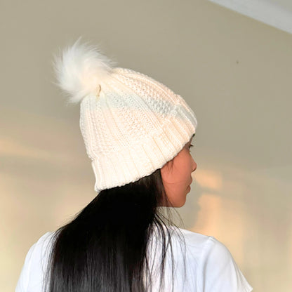 girl with black hair wearing a white beanie with satin lining in front of a cream background